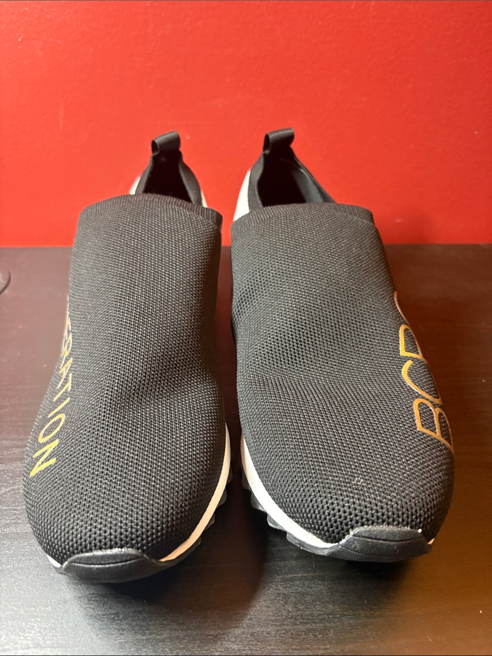 BCBGeneration Black Knit Slip-On Sneakers with Gold Logo Accent